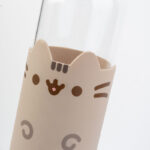 Zbliżenie na silikonowy ochraniacz butelki z twarzą kota Pusheen i różowym noskiem