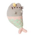 Maskotka Pusheen Syrenka – widok z boku. Szary kotek z uroczą żółtą gwiazdką na głowie, klasycznymi brązowymi wąsikami i przednimi łapkami. Dół maskotki zdobi ogon syreni w pastelowej zieleni z różowym konturem łusek i delikatnym, skrzyżowanym ogonkiem. Świetna do przytulania i jako dekoracja w morskim klimacie!