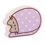Gumka Pusheen w kształcie śpiącej kotki w kocyku w kropki, na białym tle.